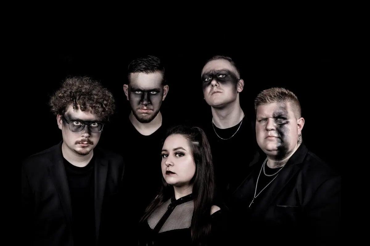 Bandfoto von Ultraviolett: fünf Bandmitglieder in Schwarz mit dunklem Bühnen-Make-up