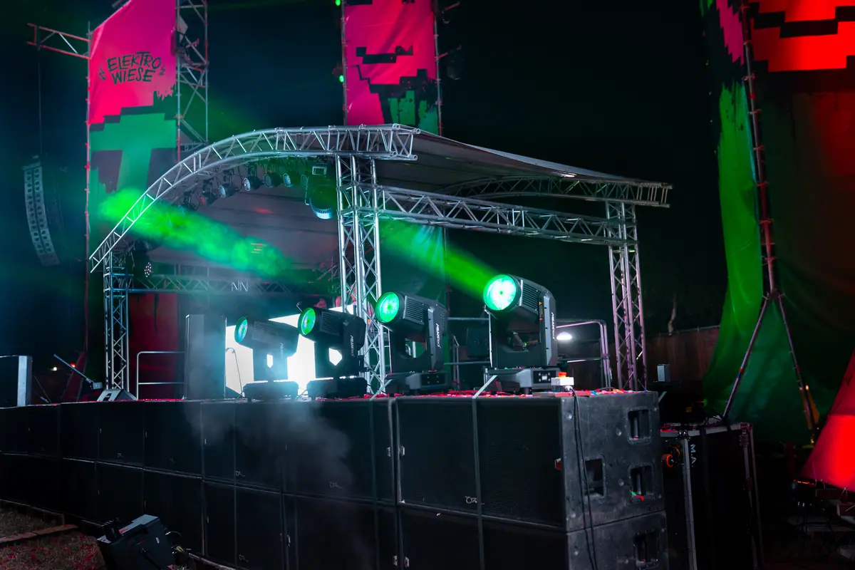 Bühne mit Traversendach, grünen Moving Heads und Subwoofern