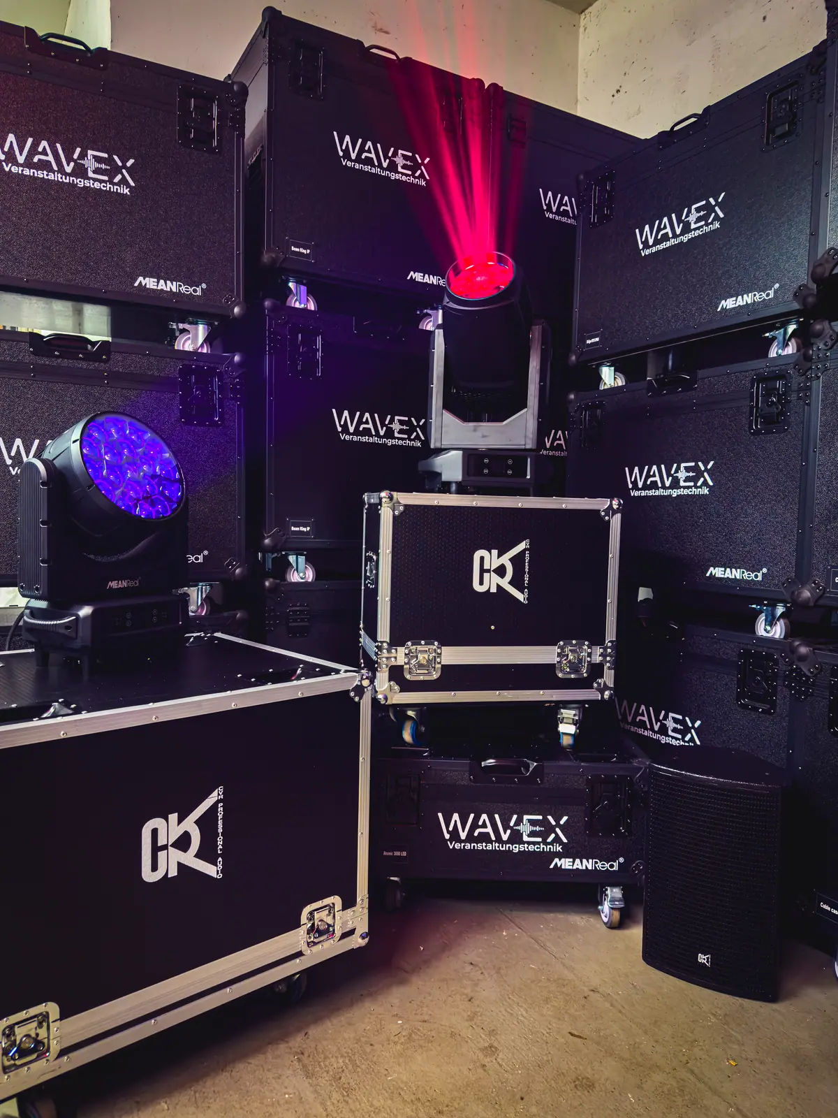 Moving Heads und Flightcases mit WaveX-Logo im Lager, rot und blau beleuchtet